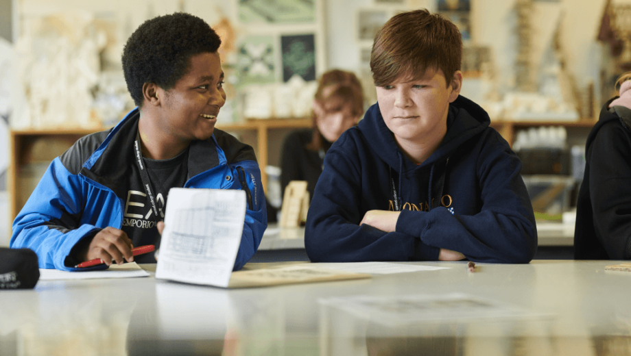 Two students talking to each other in class