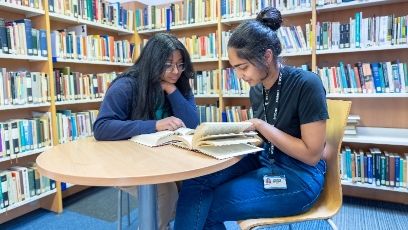Two Students in the Library reading books. college in merseyside