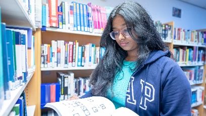 A student reading a book in the Library.