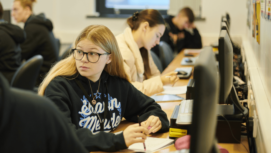 Female student sat at computer doing btec computing