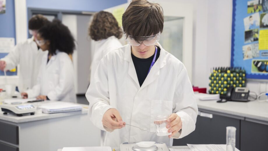 a student completing a experiment with lab coat and PPE