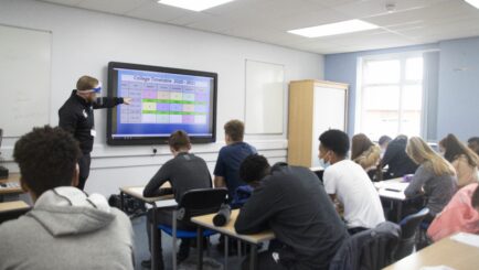 Students in a classroom looking at a screen