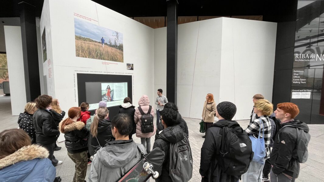 a group of students looking at artwork in a gallery