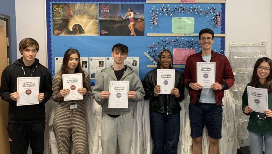 Students holding certificates up in a Chemistry lab