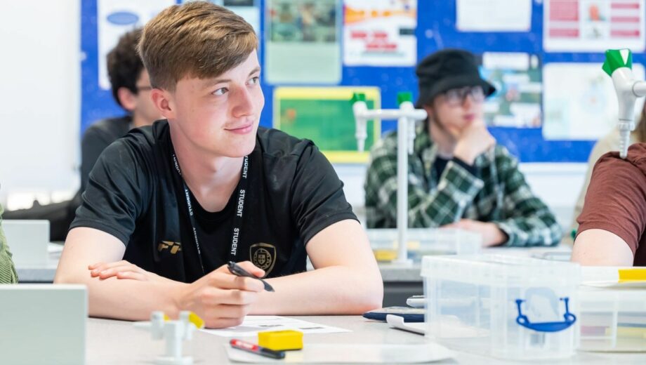 Male student sat in science classroom. St helens college