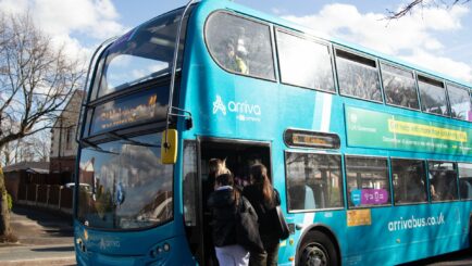 Students entering a bus at Carmel College Merseyside