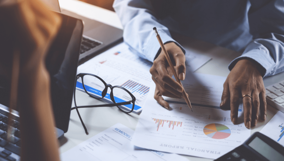 Hands writing over finance documents