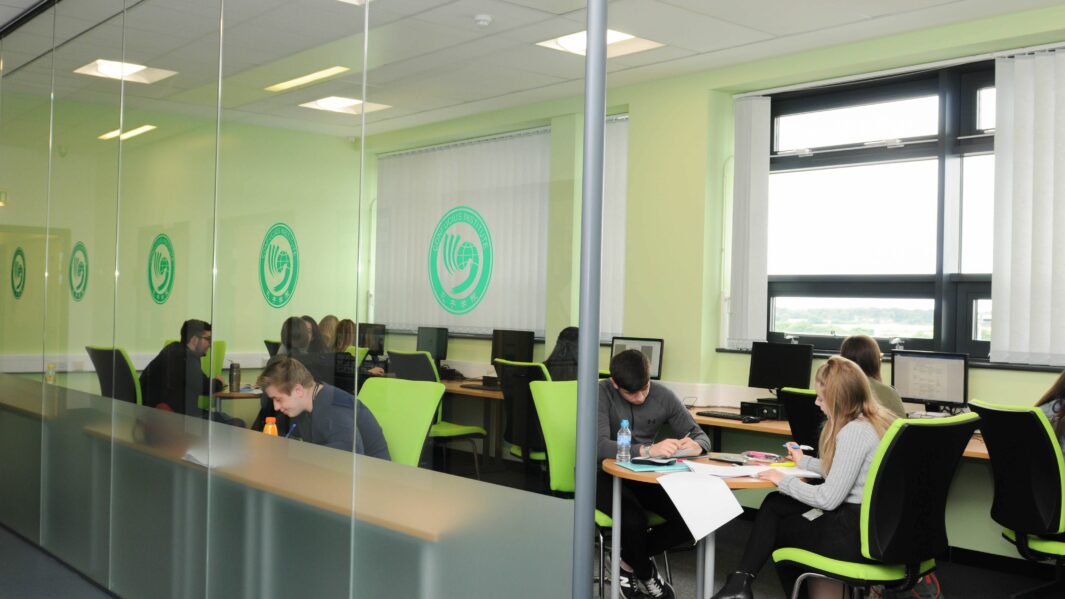 Workbase students working at desks in Carmel College.