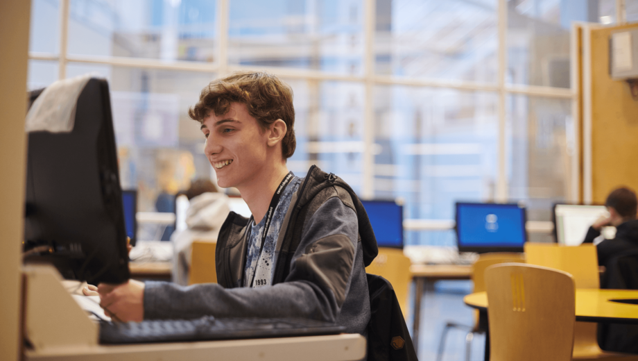 male student at a PC in the Carmel college library