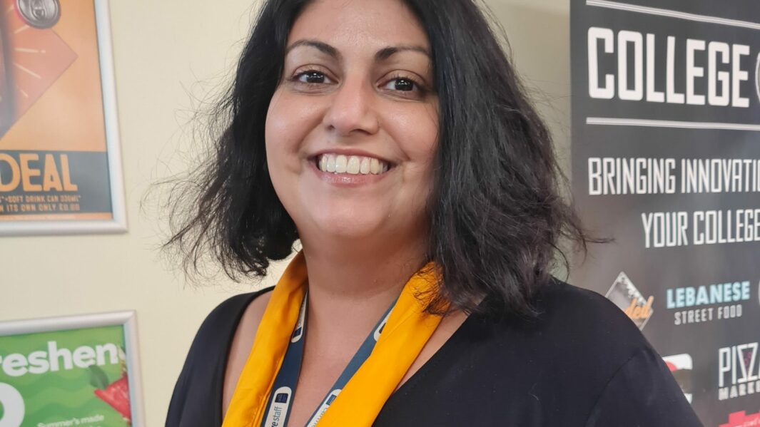 Image of female tutor wearing black jumper and yellow scarf