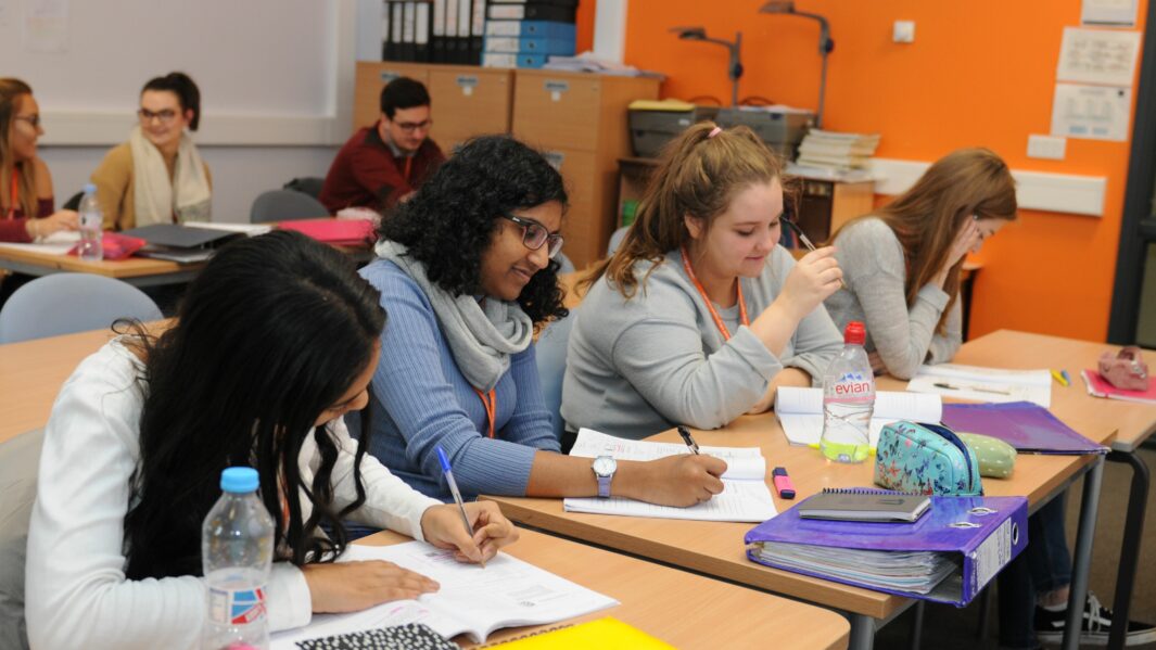 Group of HE students in a classroom working at desks at carmel College