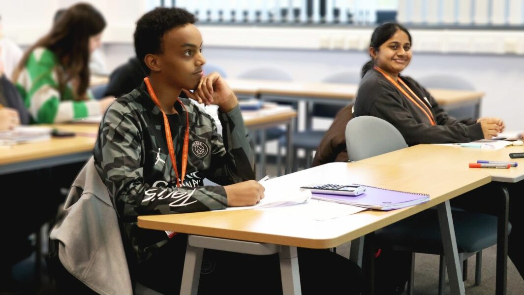 Male and female HE students working at desks in Carmel College