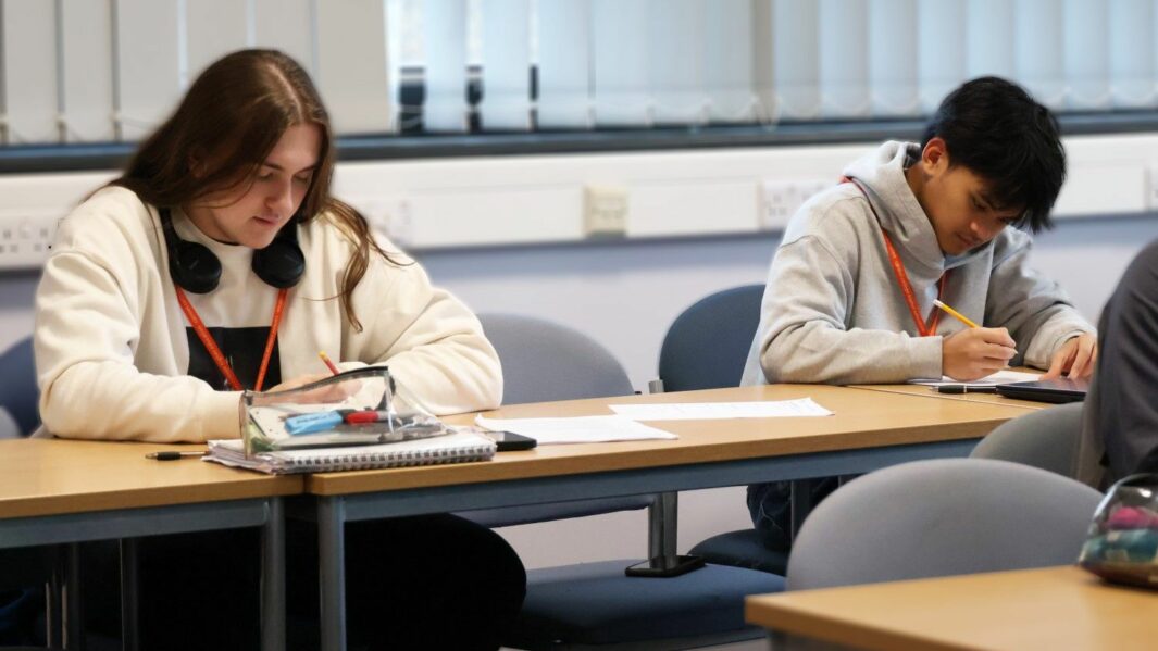 male and female HE students working at desks in Carmel College