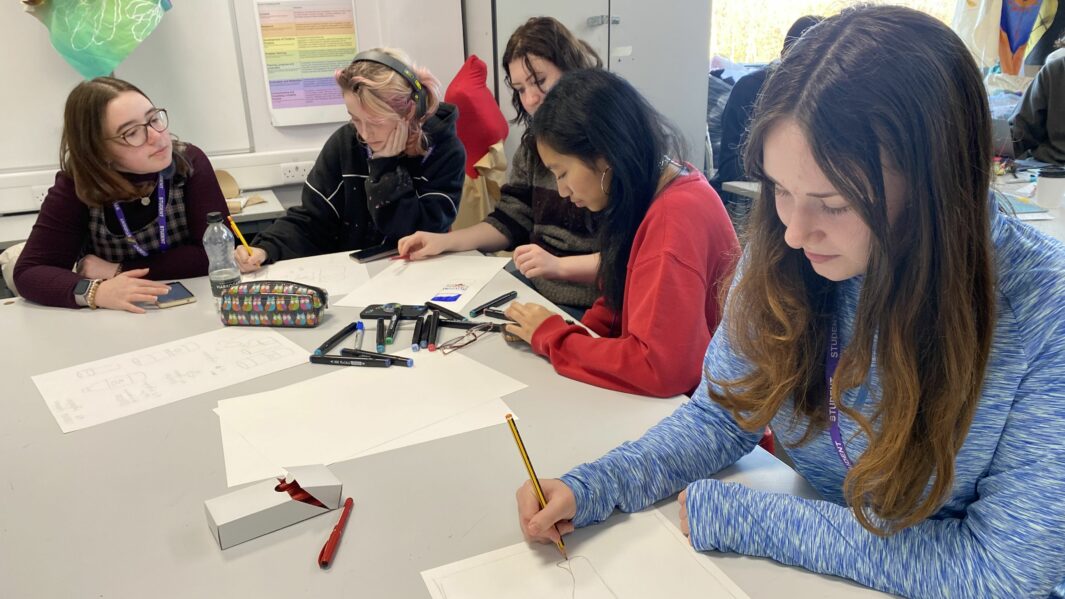 Students working at a desk in art