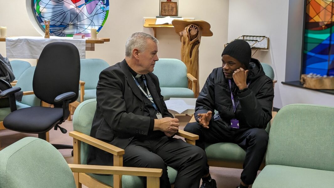 Man and student sat on chairs in Chaplaincy talking
