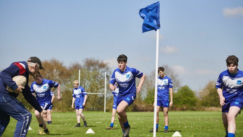 A rugby match taking place outside on the sports field at Carmel College