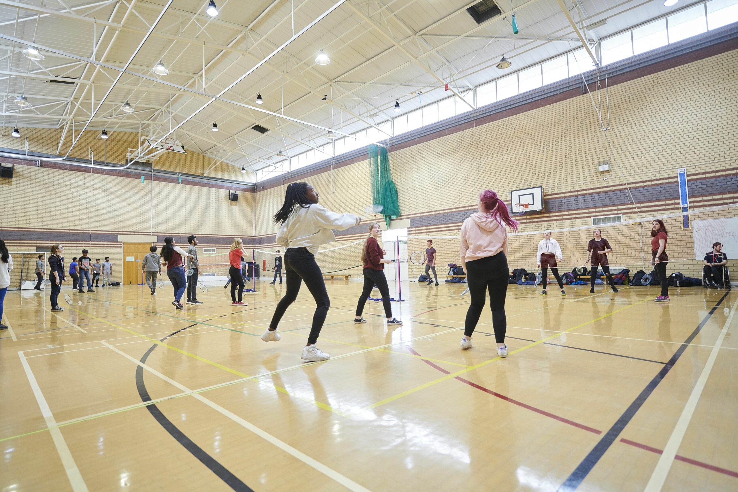 Students playing badminton in the sports hall at Carmel college