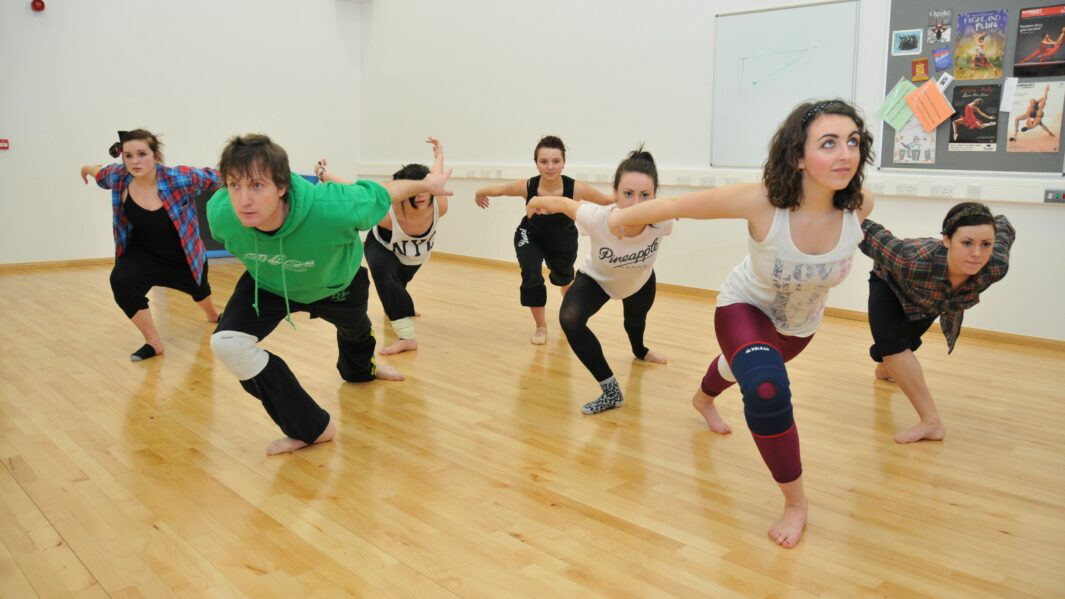 Male and female students dancing in the dance studio at Carmel College