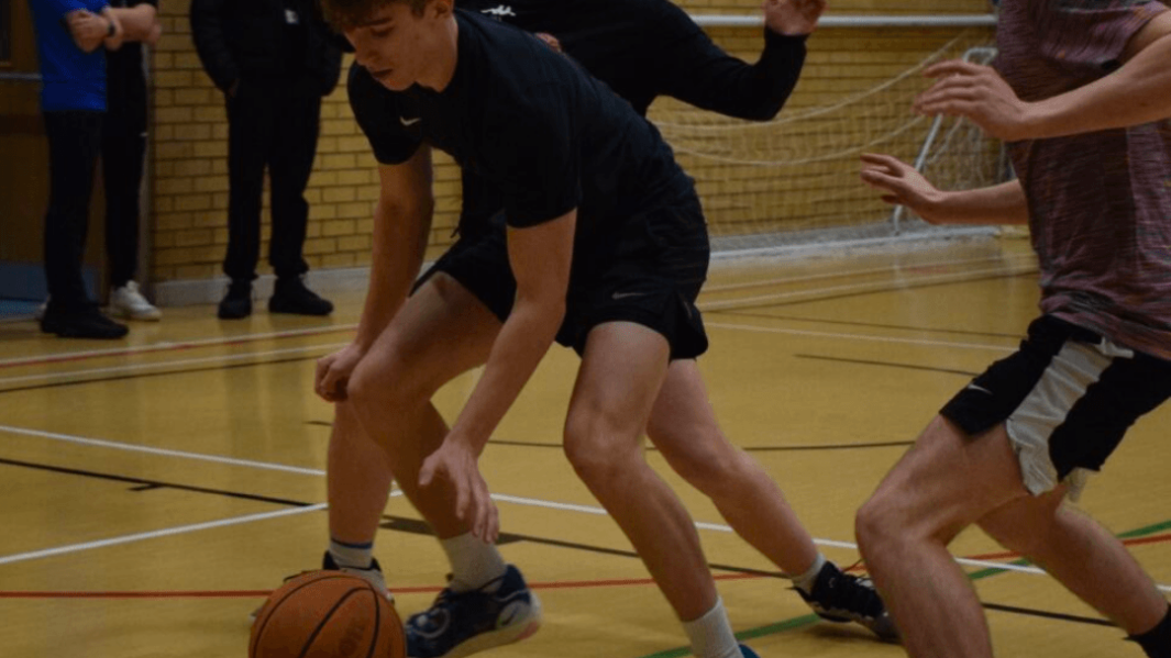 Students and staff in basketball match