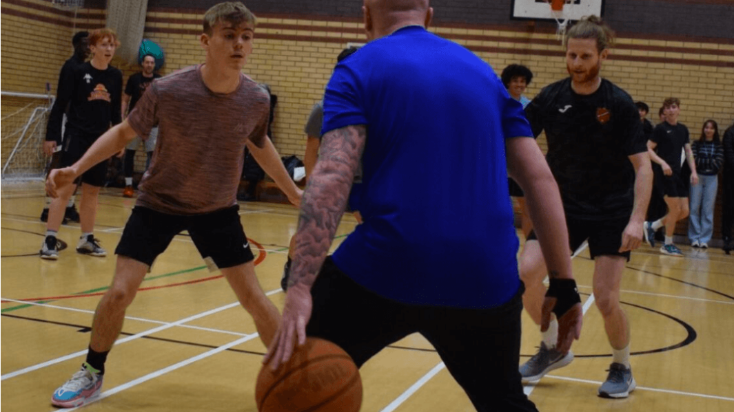 Students and staff in basketball match