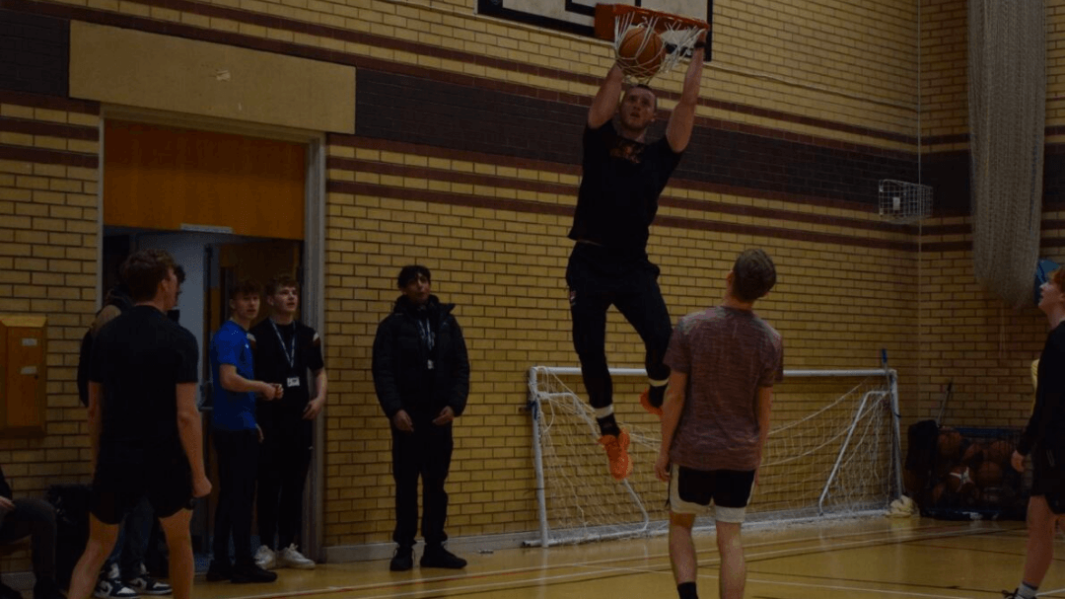 Students and staff in basketball match