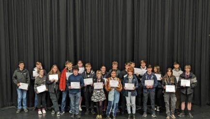 Group of students in theatre with certificates