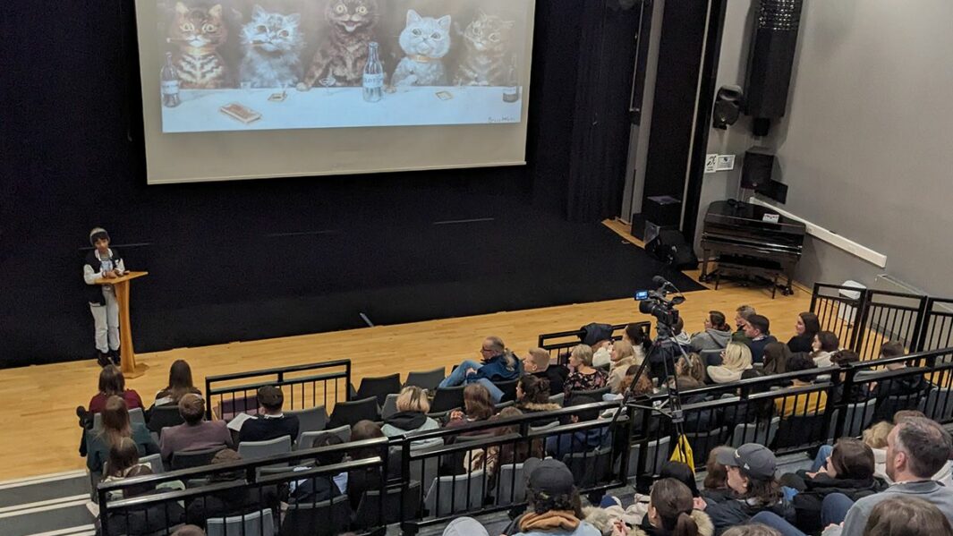 tudent presenting in the theatre to an audience
