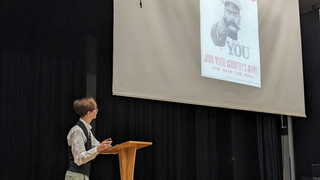 Male student presenting to an audience in the theatre