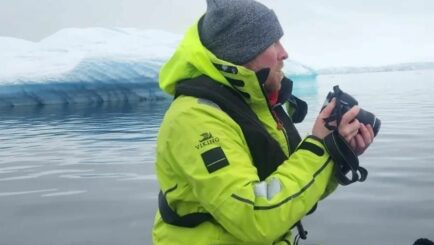 Photo of Jcak McElhinney in Antartica wearing a hi vis jacket and hat
