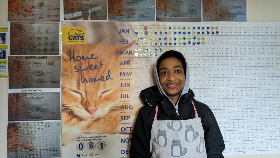 Photo of a female student next to a notice board at Cats protection