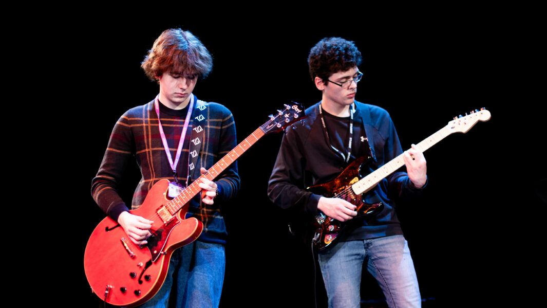 Two male students playing guitar