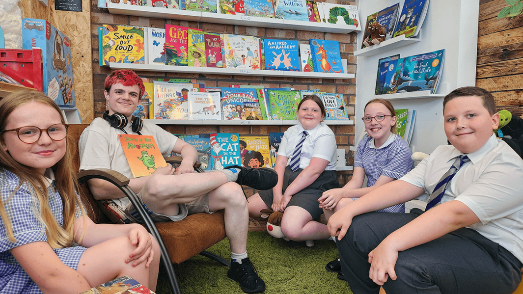 Carmel College Foundation Learning student performs live reading of Have A Go Avocado to Eaves Primary School students at launch event in St Helens Book Stop