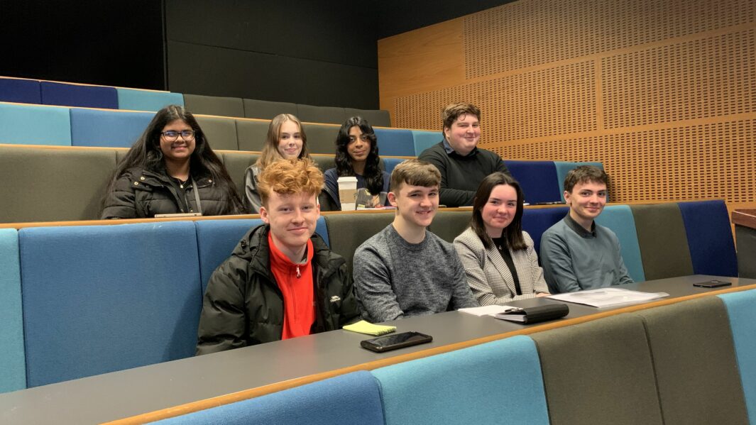Eight male and female students sat on chairs at the European Youth Parliament