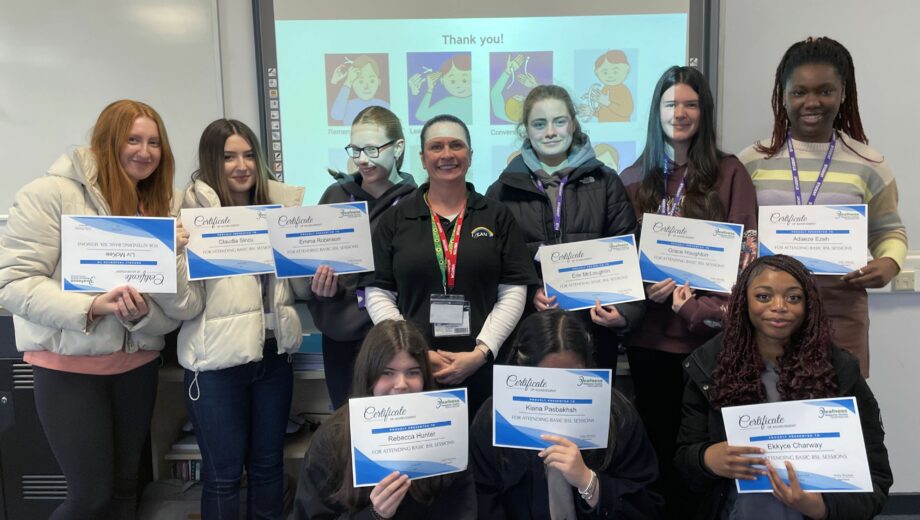 Group of students holding up their first aid certificates