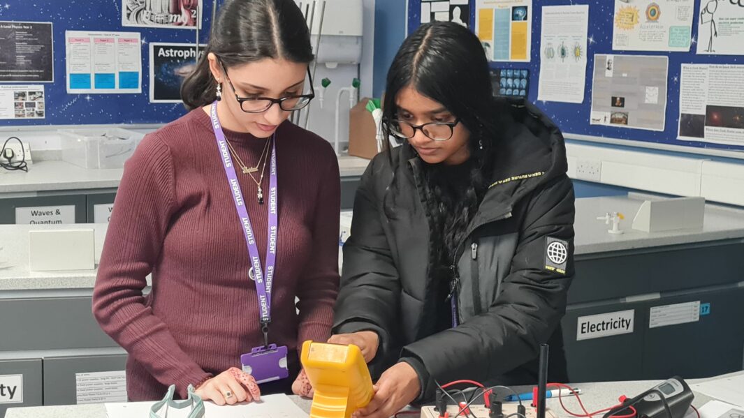 Two female students doing a Physics experiment in a lab
