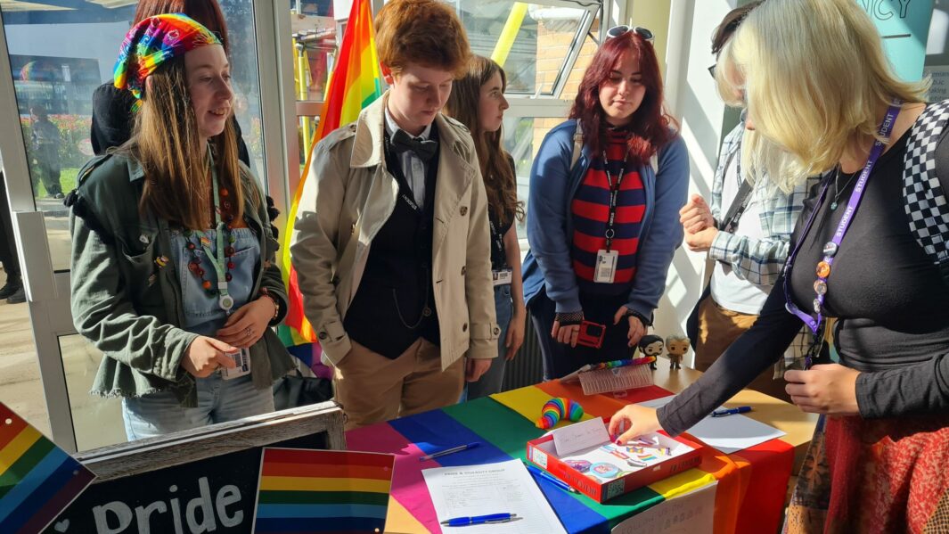 Group of male and female students stood on the Pride and Diversity Stand