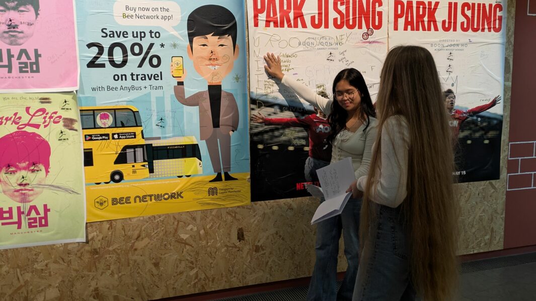 2 female students pointing at some artwork in a gallery