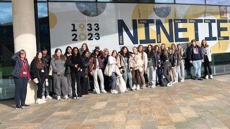 A large group of health & social care students outside Edge Hill University on a trip