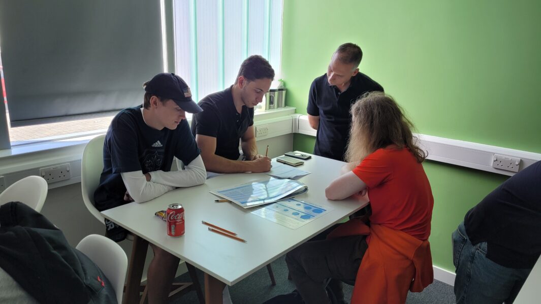 Students sat around a desk table working