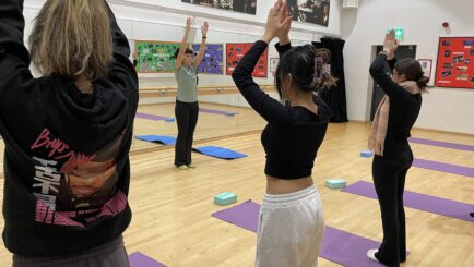 Students taking part in yoga in the dance studio