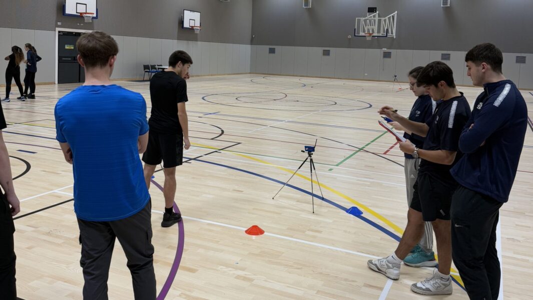 Students taking photos in a sports hall