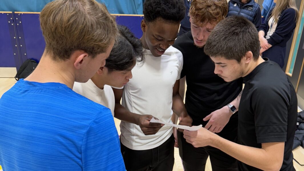 Students working together in a group in a sports hall
