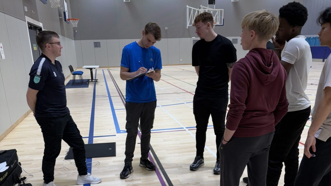 Sports students take notes in sports hall