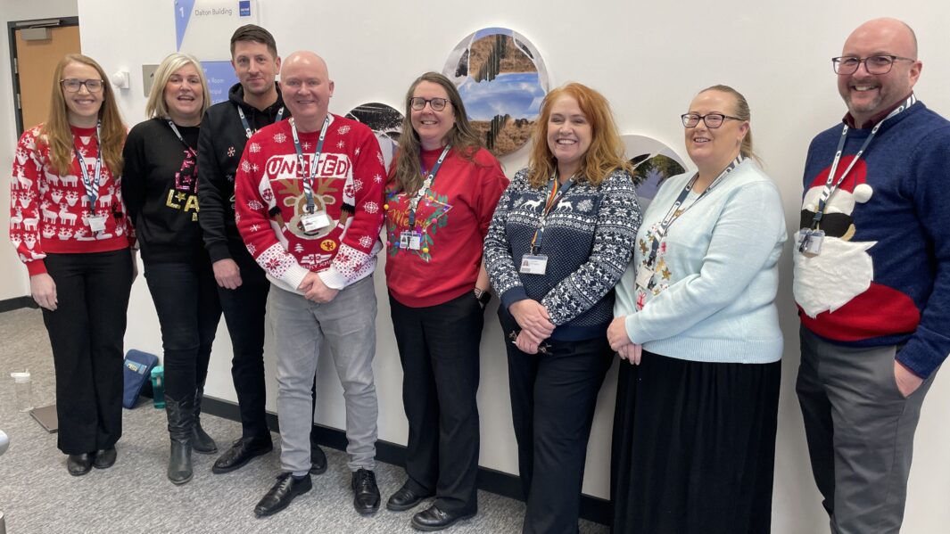 Carmel College managers stood in a line wearing Christmas jumpers