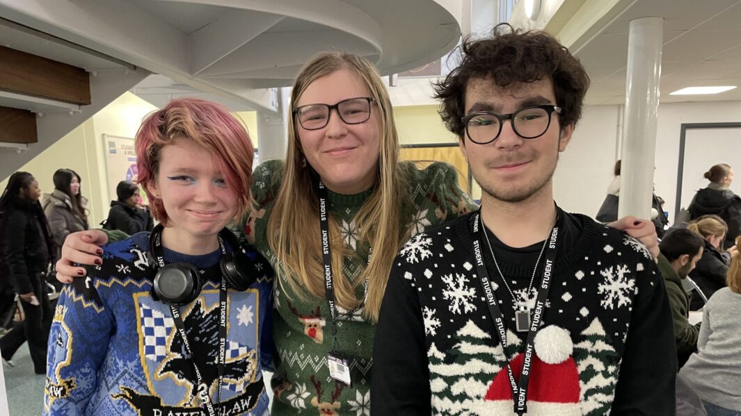 3 students wearing xmas jumpers