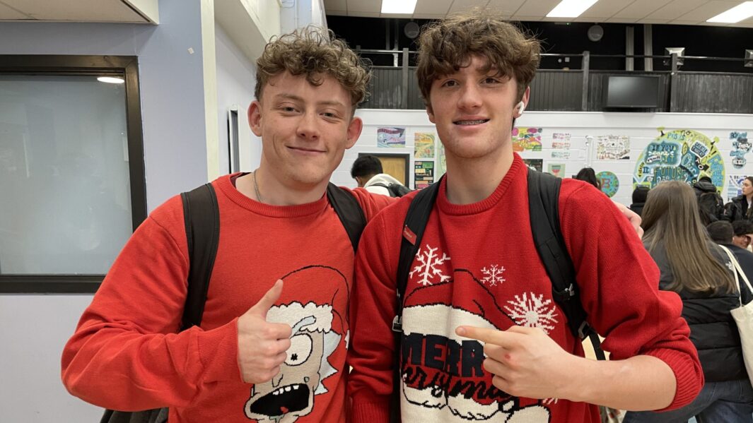 2 male students wearing xmas jumpers