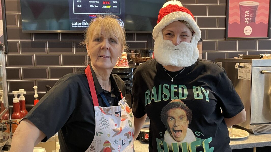 2 cafe members of staff wearing christmas jumpers