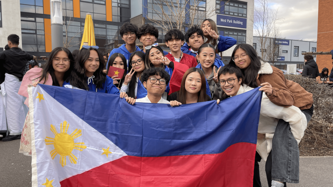 Carmel College's Asian society pose as a group with Philipe