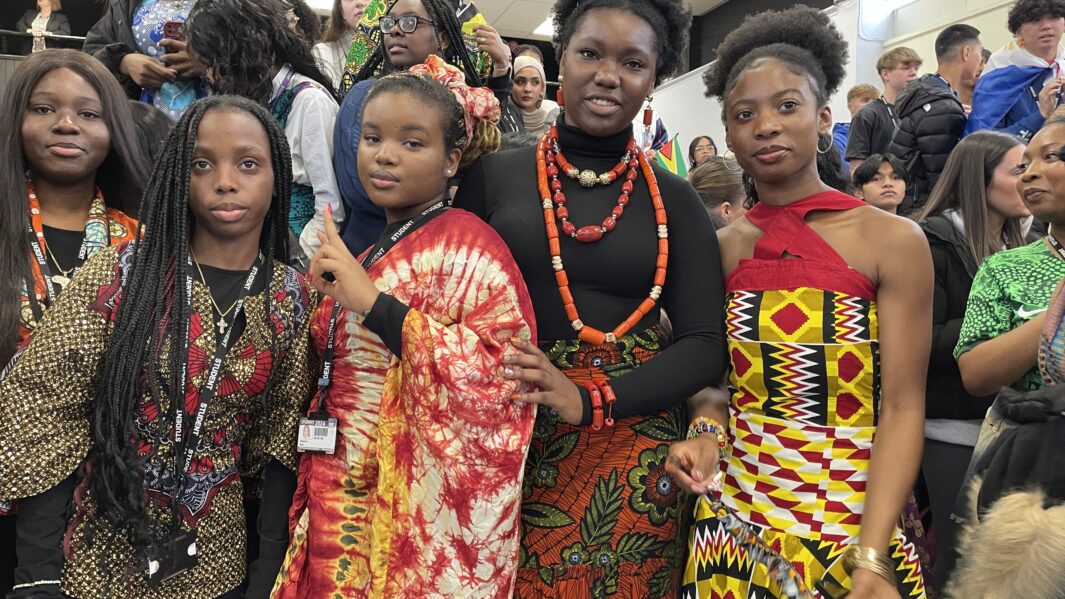 Group of female Carmel African Caribbean society students dressed in African Caribbean cultural clothing pose together on Carmel Cultural Appreciation Day 2024.