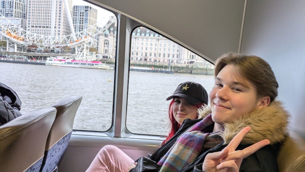 Carmel student poses with peace sign on ferry in front of the London Eye.